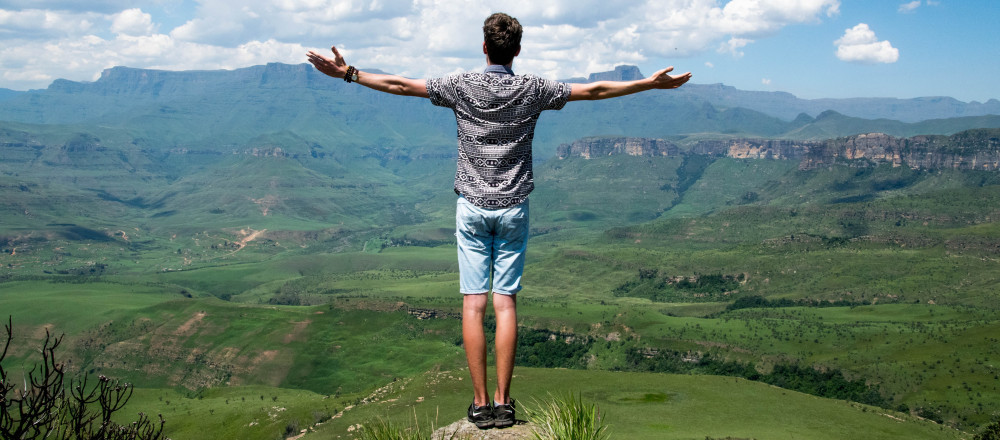 Boy standing on height showing sign of freedom