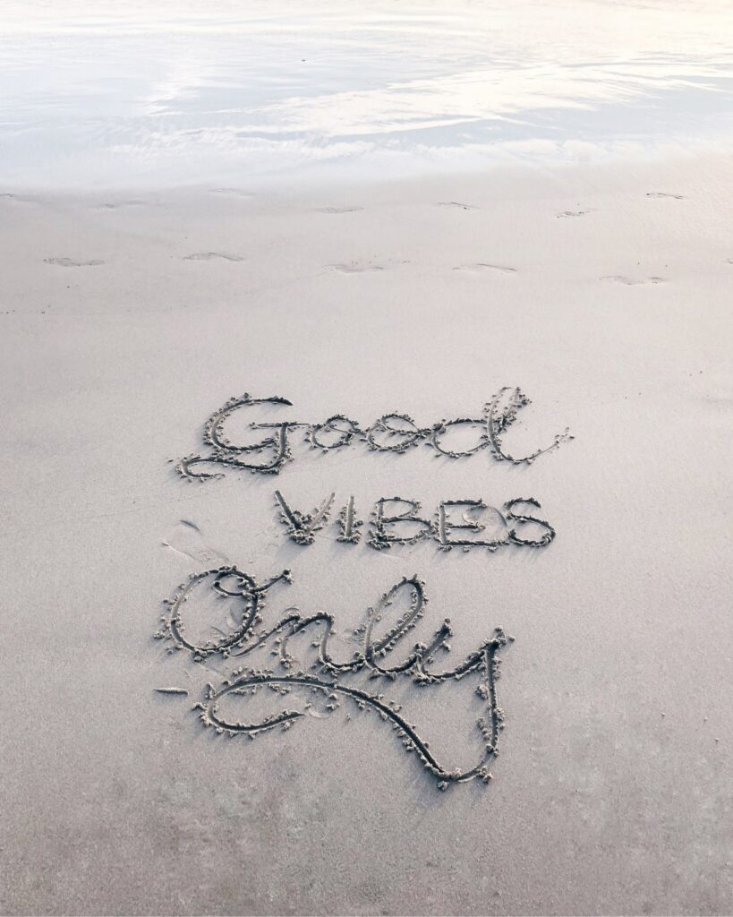 Good vibes only written on the sand